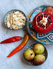 Fresh Mediterranean fruit on a blue ceramic plate. Colorful still life with pomegranate, figs, plums. Healthy eating concept. 