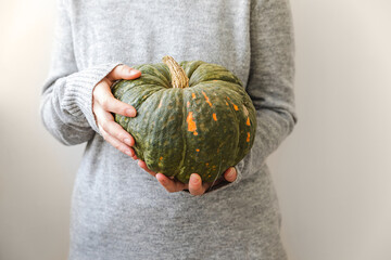 Autumnal Background. Unrecognizable woman hand holding in hands autumn fall pumpkin isolated on...
