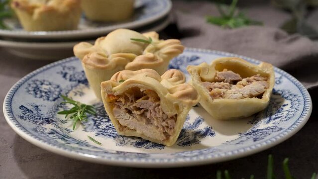 Typical portuguese snack with meat. Chicken pies know as empadas de frango or galinha on old fashioned ceramic plates.