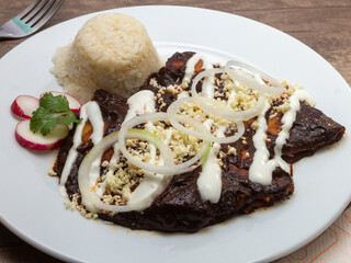 mexican food enchiladas with mole, tomato sauce, green sauce