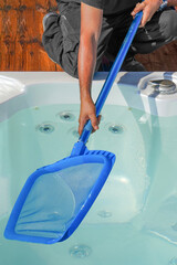 Hand of african maintenance hotel staff worker cleaning hot tub