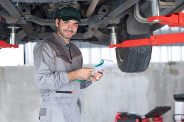 Fototapeta premium Professional mechanic providing car repair and maintenance service in auto garage. Car service business concept.