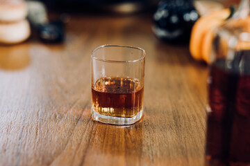 a glass of whiskey on wood bar, soft focus.	