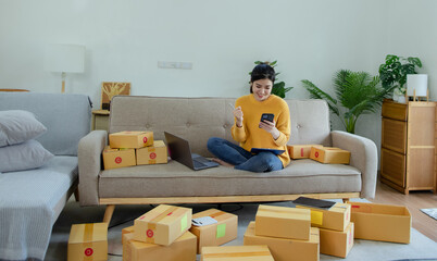 Happy asian young businesswoman using laptop computer online chat with packaging box, Business online influencer on social media concept, Online Selling, Online Shopping to market.