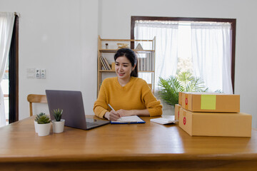 young businesswoman using laptop computer online chat with packaging box, Business online influencer on social media concept, Online Selling, Online Shopping to market.