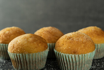 Set of delicious freshly baked cupcakes with sugar on top on a background