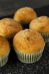 Set of delicious freshly baked cupcakes with sugar on top on a background
