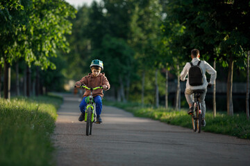 Boy learning to ride bike. Child travels through urban alley