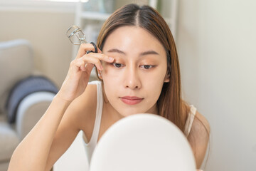 Happy beauty concept, asian young woman, girl make up face hand using eyelash curler on long...