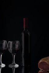 wine still life with jerky on a black background
