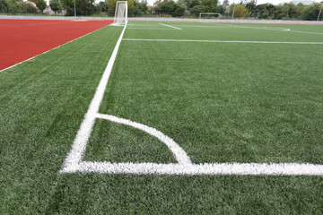 corner of a football artificial field with white markings in the stadium