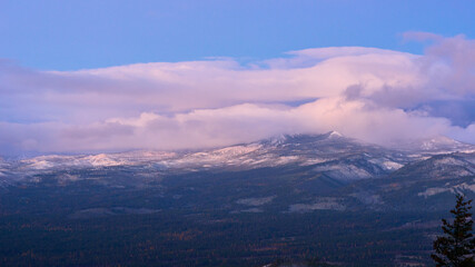 Landscape with the mountains in the clouds at sunrise.