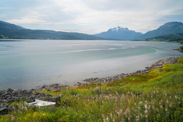 Fototapeta premium a small wooden boat in the shore of a lake in Lofoten Islands, Norway
