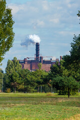 A factory with a smoking chimney in the distance. Problems of ecology and environmental pollution....