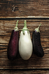 
Fresh purple and white eggplant with water drops on wooden background