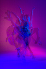 Dancing young mixed race girl enjoying moving in colorful neon studio light. Long exposure. woman dancing on roller skates, figure skating