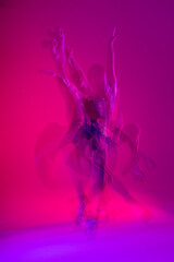 Dancing young mixed race girl enjoying moving in colorful neon studio light. Long exposure. woman dancing on roller skates, figure skating - obrazy, fototapety, plakaty