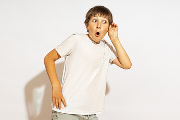 the boy eavesdrops on the neighbors. opened his mouth in surprise. studio shot. hard light.
