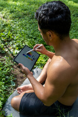young man explaining drawing on his tablet, while teaching chakra, yoga and meditation class, mexico