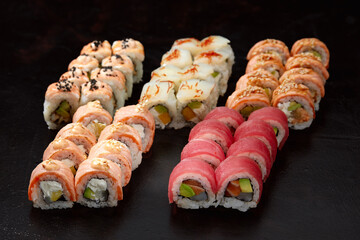 Top view background with set of colorful different kinds of sushi rolls placed on wooden board