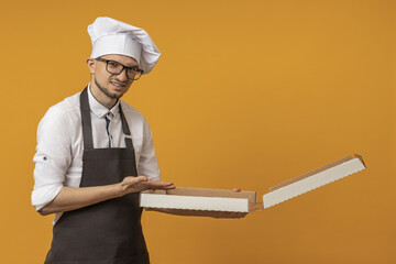the chef opened the pizza box and is unhappy looking at the camera on a yellow background.