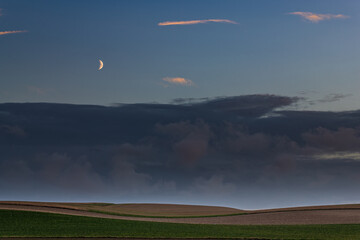 Landscape with the moon rising and clouds in the sky