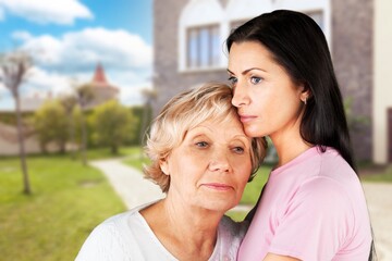 Obraz premium Adult woman with her senior mother in park