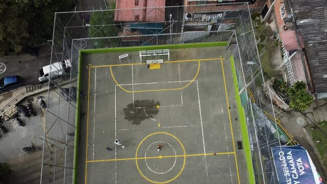 playing football in the suburban field in the favela slum - drone resumes the game of children in the poor areas of the city of Medellin Colombia at Comuna 13  reborn e
with art and sport