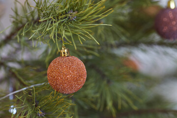 Jute ball with lace on the Christmas tree on a wooden background. A burlap bow. Rustic Christmas decorations.