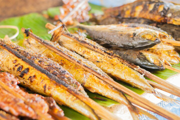 The chef prepares grilled food for customers,