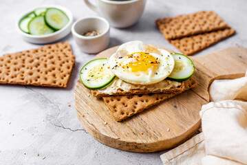 Healthy crispbread breakfast. Whole wheat with cream cheese, cucumbers and egg.  Whole Grain...