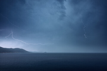 Naklejka na ściany i meble Scenery of lightning over the sea in the morning. Lagurian Sea, Laigueglia, Italy