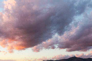 Sunset with dark clouds over the mountain silouette