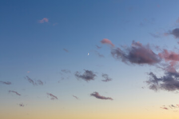 Sunset sky with dark clouds and the moon