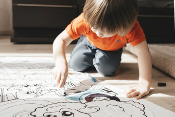 Child holding in his hand colorful marker. Early education concept. Toddler drawing. Art therapy. Development of fine motor skills. Kid playing and having fun. Preschool lifestyle