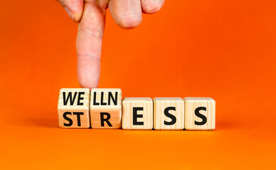 Stress or wellness symbol. Concept words Stress or Wellness on wooden cubes. Businessman hand. Beautiful orange table orange background. Business stress or wellness concept. Copy space.