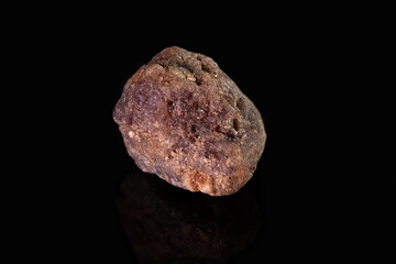 A small piece of the mineral spinel. Brown stone with a porous surface