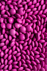 Pink candy coated chocolate button sprinkle texture - M&Ms, Smarties, sprinkles