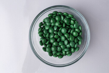 Green candy coated chocolate button sprinkles in a bowl on marble - M&Ms, Smarties, sprinkles