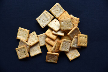 Delicious peppery cookies in a white plate on a black background.