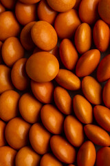 Close up of orange candy coated chocolate button sprinkle texture - M&Ms, Smarties, sprinkles