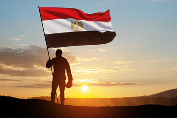Silhouette Of A Solider with Egypt Flag Against the Sunrise in desert . Concept - armed forces of...