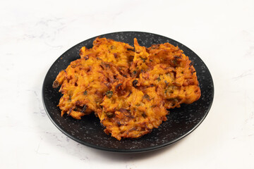 Indian spicy vegetable pakora or pakoda served in dish isolated on table top view