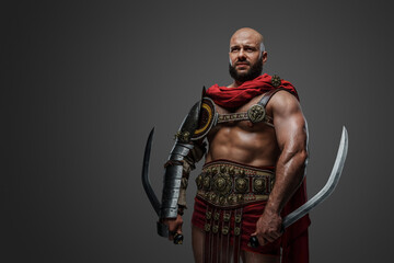 Shot of violent praetorian warrior with two swords dressed in armor and red cape.