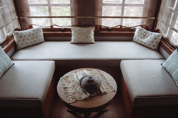 divan with several pillows in front of window