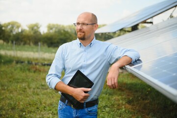 The portrait of a proud engineer smiles satisfied with his successful work. Concept: renewable energy, technology, electricity, service, green power