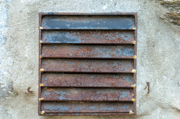 Old rusted external ventilation louvres on fasade of house
