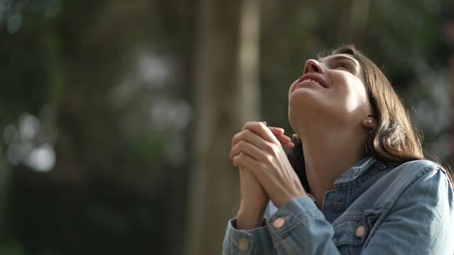 Hopeful happy woman looking at sky smiling. Faithful spiritual person celebrating life