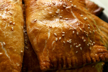 Baked delicious buns with sesame seeds. Fresh crispy pies