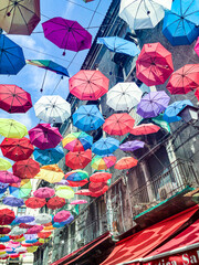 Fototapeta na wymiar colorful umbrellas in the old town of Palermo as decoration in the pedestrian zone with facade of historic old houses